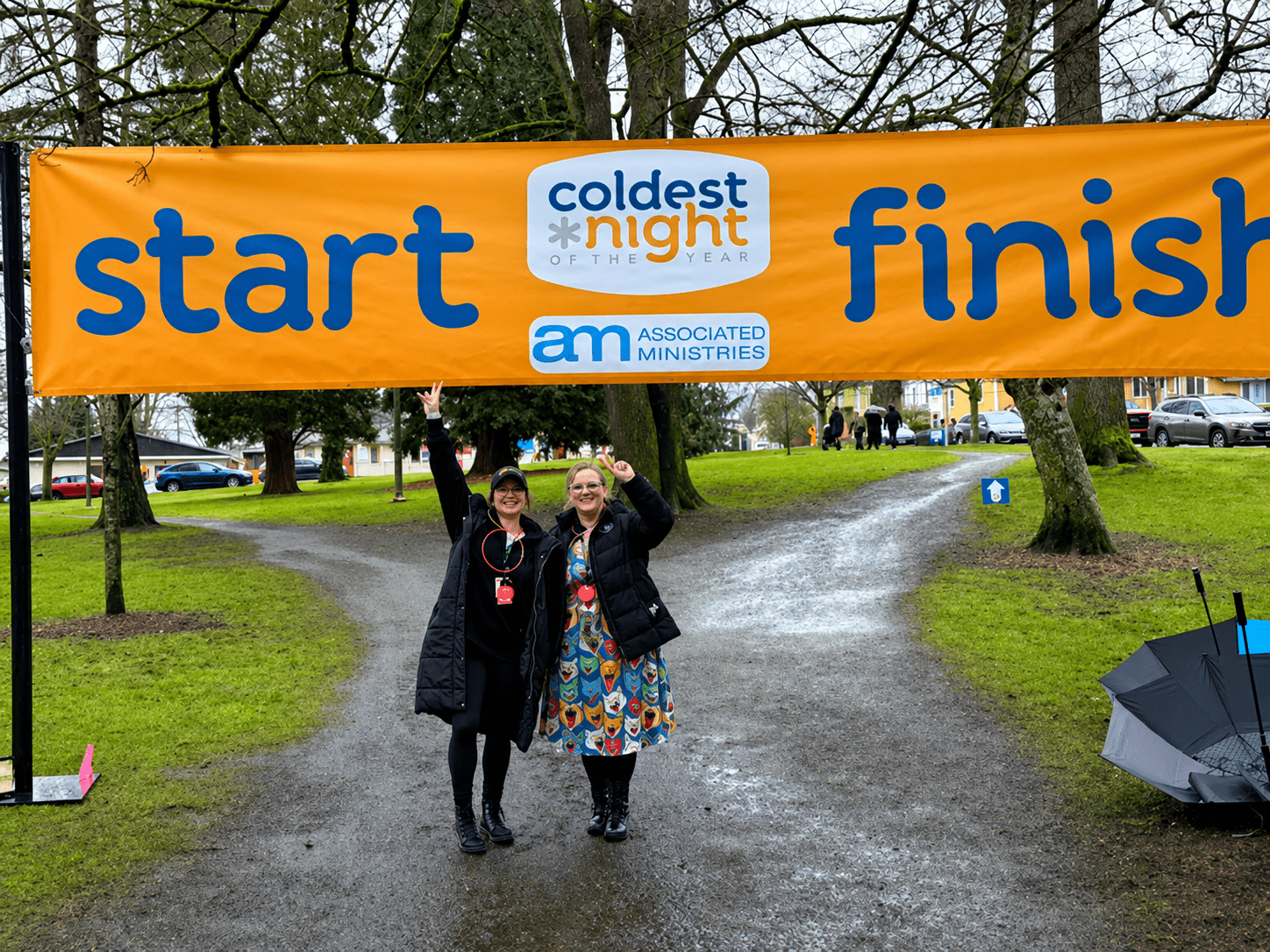 Two people under "start/finish" banner outdoors.