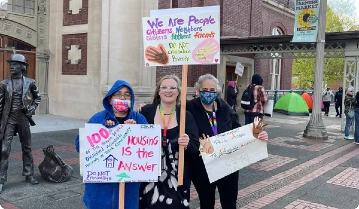 People holding signs at a housing protest.